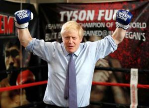 MANCHESTER, ENGLAND - NOVEMBER 19: Britain's Prime Minister Boris Johnson poses for a photo wearing boxing gloves emblazoned with "Get Brexit Done" during a stop in his General Election Campaign trail at Jimmy Egan's Boxing Academy on November 19, 2019 in Manchester, England. Britain goes to the polls on Dec.12.