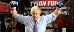 MANCHESTER, ENGLAND - NOVEMBER 19: Britain's Prime Minister Boris Johnson poses for a photo wearing boxing gloves emblazoned with "Get Brexit Done" during a stop in his General Election Campaign trail at Jimmy Egan's Boxing Academy on November 19, 2019 in Manchester, England. Britain goes to the polls on Dec.12.