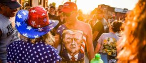 STURGIS, SD - AUGUST 07: Johne Riley walks down Main Street showing off his chest painted with a portrait of President Donald Trump during the 80th Annual Sturgis Motorcycle Rally on August 7, 2020 in Sturgis, South Dakota. While the rally usually attracts around 500,000 people, officials estimate that more than 250,000 people may still show up to this year's festival despite the coronavirus pandemic.
