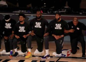 LAKE BUENA VISTA, FLORIDA - JULY 30: LeBron James #23 and Anthony Davis #3 of the Los Angeles Lakers in a Black Lives Matter Shirt kneel with their teammates during the national anthem prior to the game against the LA Clippers at The Arena at ESPN Wide World Of Sports Complex on July 30, 2020 in Lake Buena Vista, Florida.