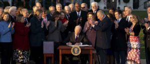 U.S. President Joe Biden, center, signs H.R. 3684, the Infrastructure Investment and Jobs Act, during a ceremony on the South Lawn of the White House in Washington, D.C., U.S., on Monday, Nov. 15, 2021. Biden has said the $550 billion in fresh infrastructure spending he's signing into law will help ease inflation that's raising consumer alarm and weighing on his approval rating. Photographer: Stefani Reynolds/Bloomberg via Getty Images