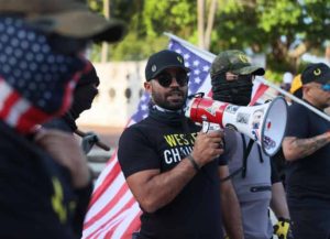 MIAMI, FLORIDA - MAY 25: Enrique Tarrio (C), leader of the Proud Boys, uses a megaphone while counter-protesting people gathered at the Torch of Friendship to commemorate the one year anniversary of the killing of George Floyd on May 25, 2021 in Miami, Florida. Mr. Tarrio lead a group to the area to express their support of police officers. Floyd's murder by Minneapolis police officer Derek Chauvin sparked global protest and continues to spur the Black Lives Matter movement. (Photo by Joe Raedle/Getty Images)