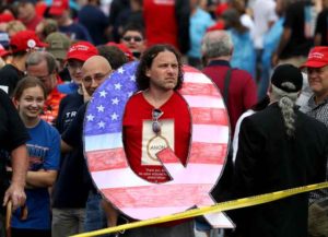 WILKES BARRE, PA - AUGUST 02: David Reinert holds a large "Q" sign while waiting in line on to see President Donald J. Trump at his rally August 2, 2018 at the Mohegan Sun Arena at Casey Plaza in Wilkes Barre, Pennsylvania. "Q" represents QAnon, a conspiracy theory group that has been seen at recent rallies. (Photo by Rick Loomis/Getty Images)