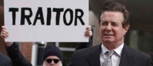 ALEXANDRIA, VA - MARCH 08: Former Trump campaign manager Paul Manafort (R) arrives at the Albert V. Bryan U.S. Courthouse for an arraignment hearing as a protester holds up a sign March 8, 2018 in Alexandria, Virginia. Manafort was scheduled to enter a plea on new tax and fraud charges, brought by special counsel Robert Mueller's Russian interference investigation team, at the Alexandria federal court in Virginia, where he resides. (Photo by Alex Wong/Getty Images)