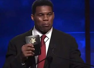 Herschel Walker displays police badge at debate (Image: YouTube)