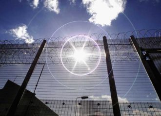 NORWICH, UNITED KINGDOM - AUGUST 25: The sun shines through high security fencing surrounding Norwich Prison on August 25, 2005 in Norwich, England. A Chief Inspector of Prisons report on Norwich Prison says healthcare accommodation was among the worst seen, as prisoners suffered from unscreened toilets, little natural light, poor suicide prevention, inadequate education and training for long-term prisoners. (Photo by Peter Macdiarmid/Getty Images)