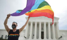 WASHINGTON, DC - JUNE 15: Joseph Fons holding a Pride Flag in front of the U.S. Supreme Court building after the court ruled that LGBTQ people can not be disciplined or fired based on their sexual orientation, Washington, DC, June 15, 2020. With Chief Justice John Roberts and Justice Neil Gorsuch joining the Democratic appointees, the court ruled 6-3 that the Civil Rights Act of 1964 bans bias based on sexual orientation or gender identity. Fons is wearing a Black Lives Matter mask with the words 'I Can't Breathe', as a precaution against Covid-19. (Photo by Chip Somodevilla/Getty Images)