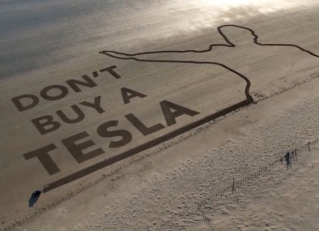 VIDEO: Anti-Musk Tesla Owner Writes ‘Don’t Buy Tesla’ In The Sand With Her Car